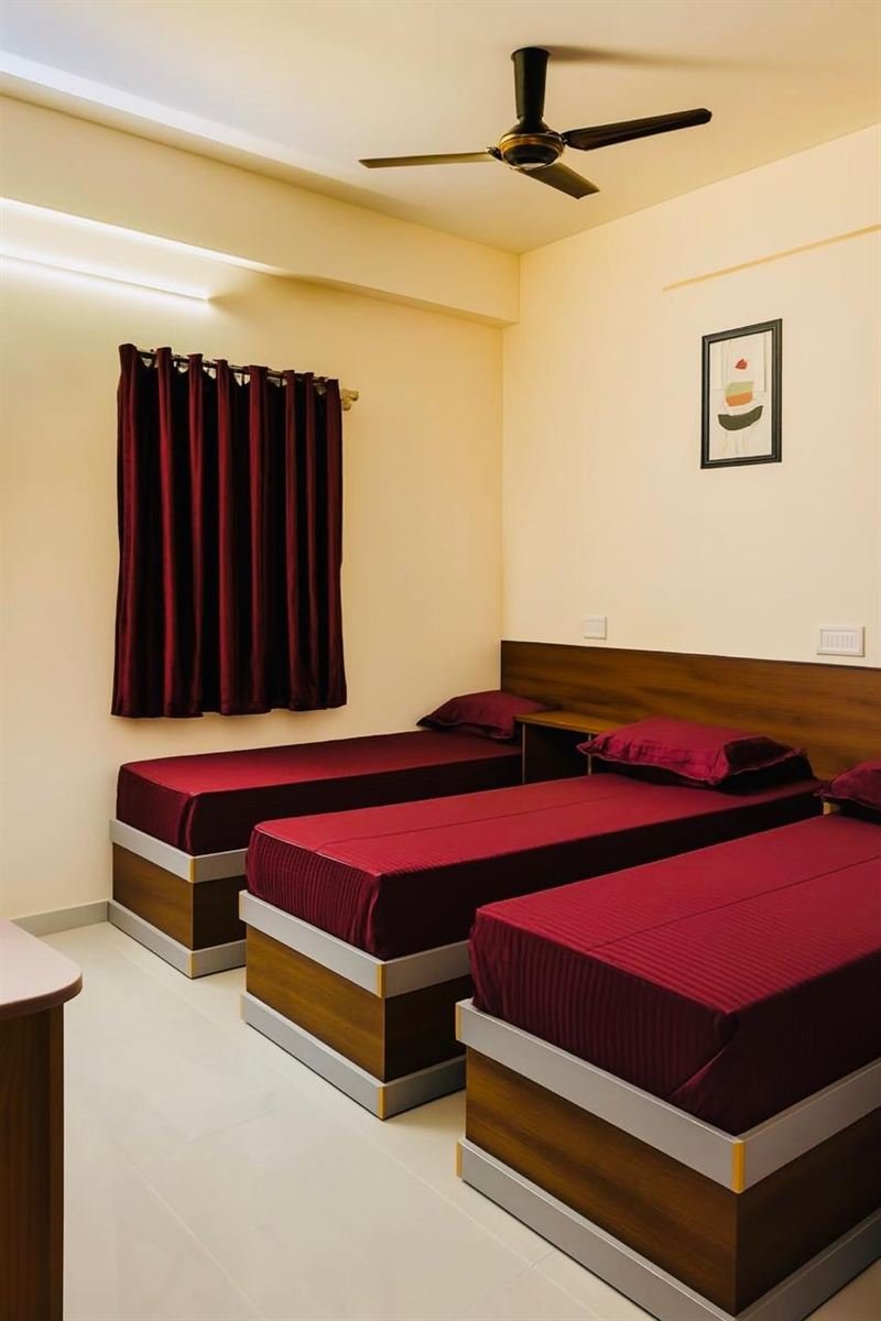 Room at AMIGO Living Premium, SG Palya — triple sharing with maroon bedding
