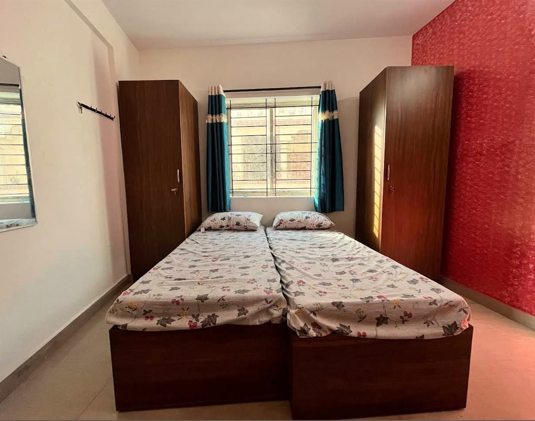 Furnished room at AMIGO Luxury ladies PG, Marathahalli — double bed with wardrobes and accent wall